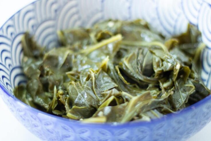 cooked collard greens in a blue and white patterned bowl.