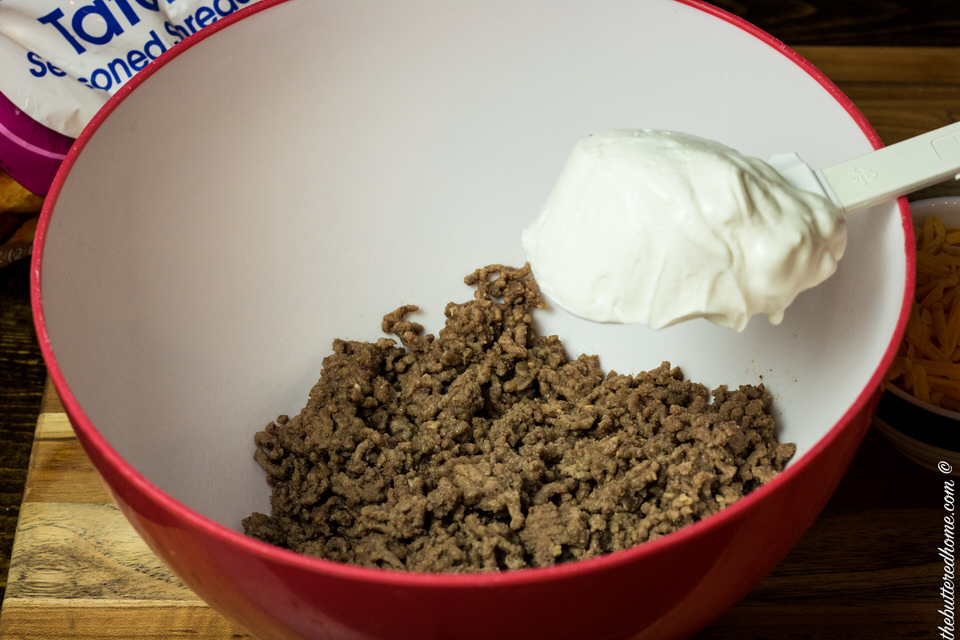 mixing sour cream with browned ground beef