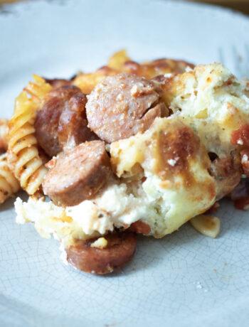 close up of baked sausage pasta on a grey plate