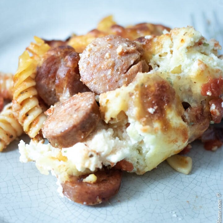 close up of baked sausage pasta on a grey plate
