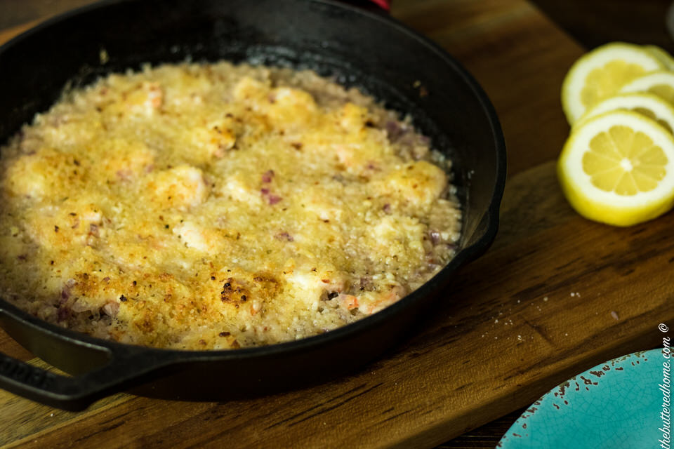 crunchy baked shrimp in a cast iron pan with lemon wedges