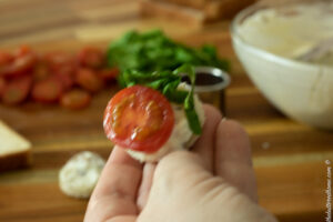 small tomato slices going on after the spread