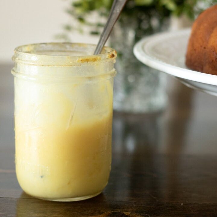 Lemon curd in a jar with a pound cake nearby