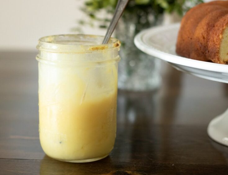 Lemon curd in a jar with a pound cake nearby