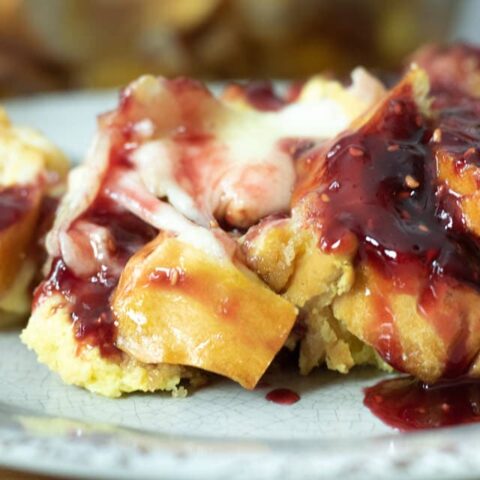 monte cristo casserole with raspberry sauce on a gray plate