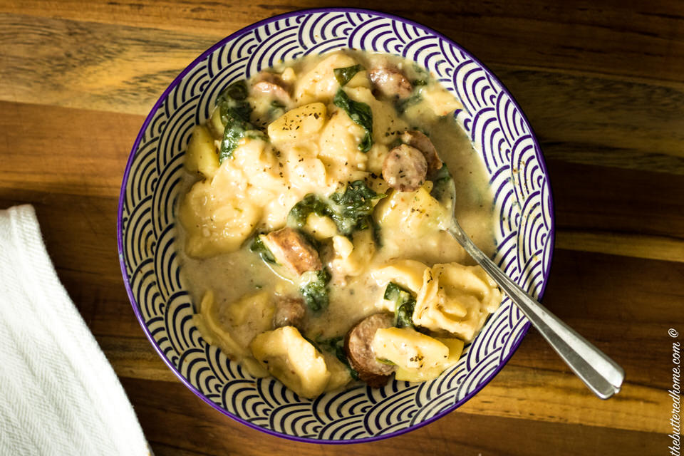 a bowl full of sausage spinach and tortellini soup