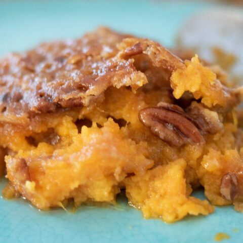 serving close up of sweet potato casserole on a blue plate