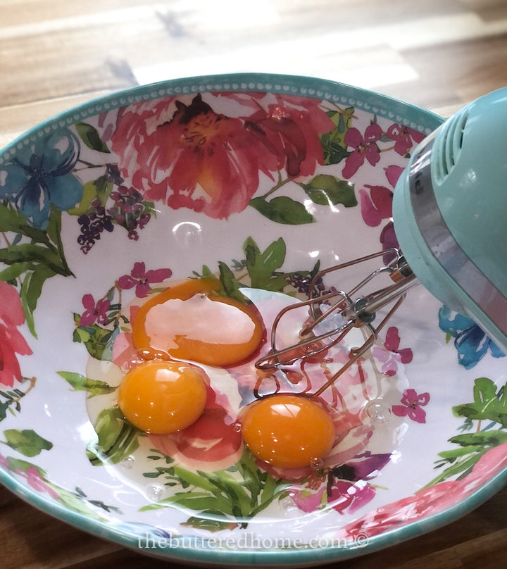 beating eggs in a floral colored bowl