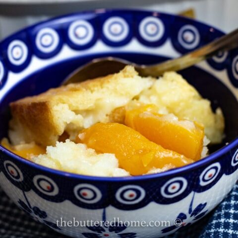 close up of peach cobbler in a blue and white bowl