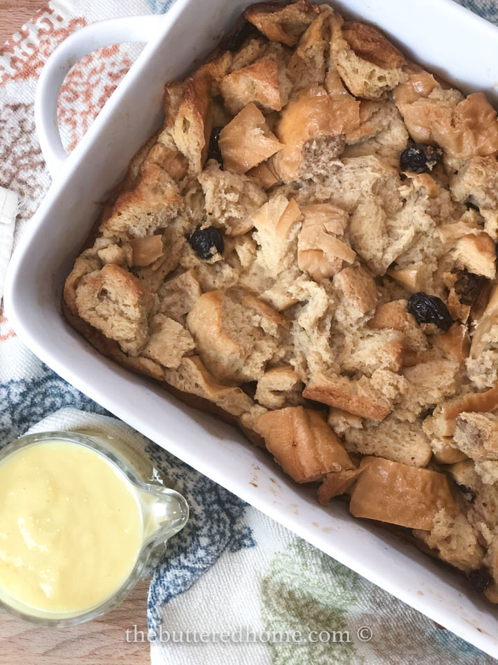 Bread pudding in white dish with bourbon sauce on the side