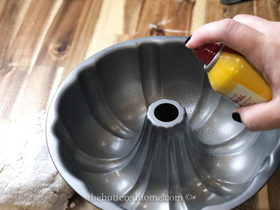spraying bundt pan with non stick spray