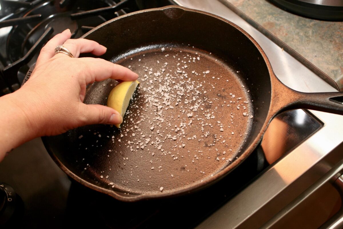 Seasoning a pan with salt and a piece of lemon.