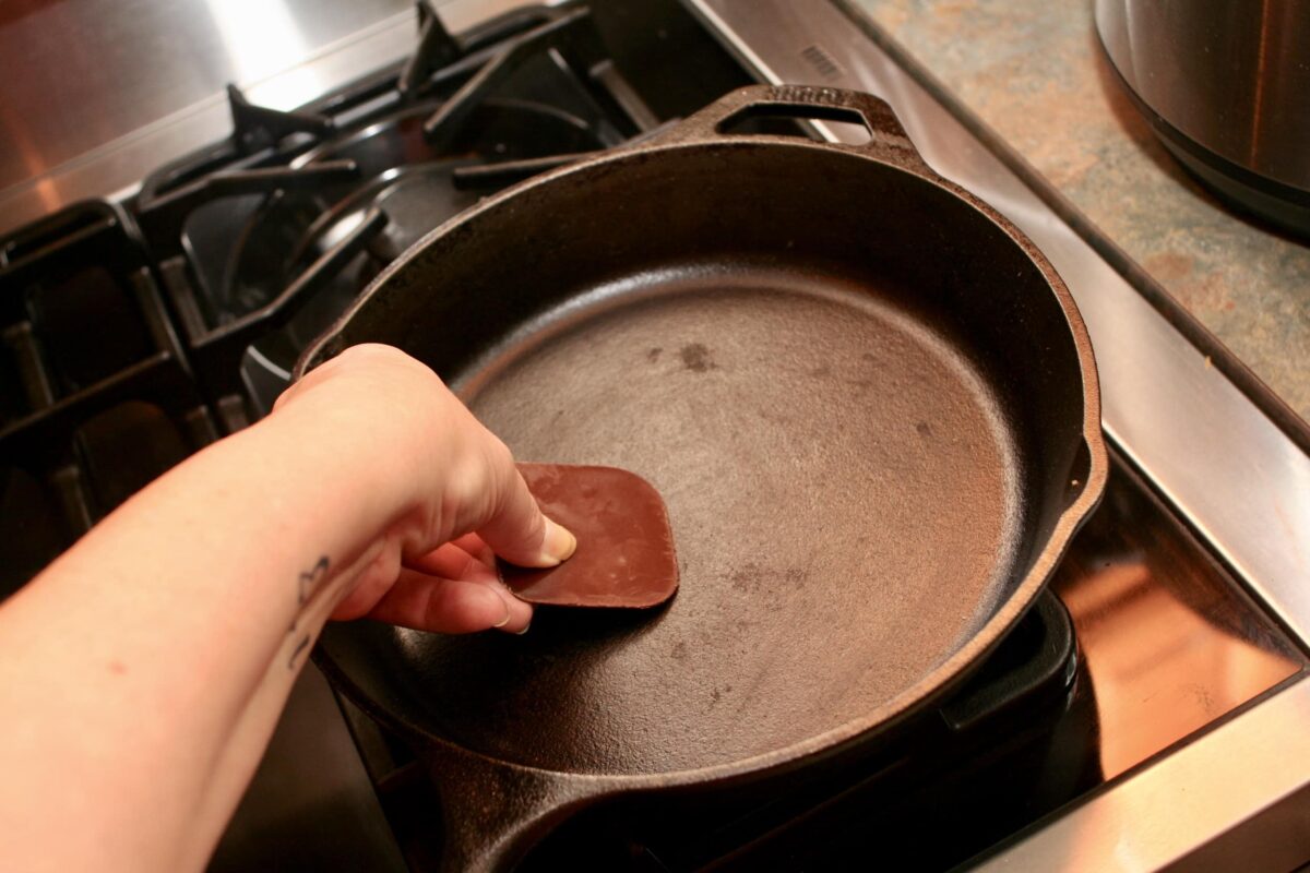 Scraping out a pan with a plastic tool.