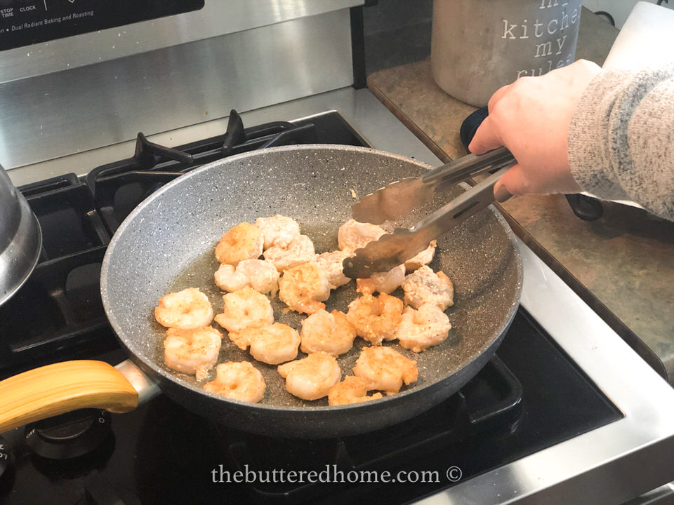 turning shrimp in frying skillet