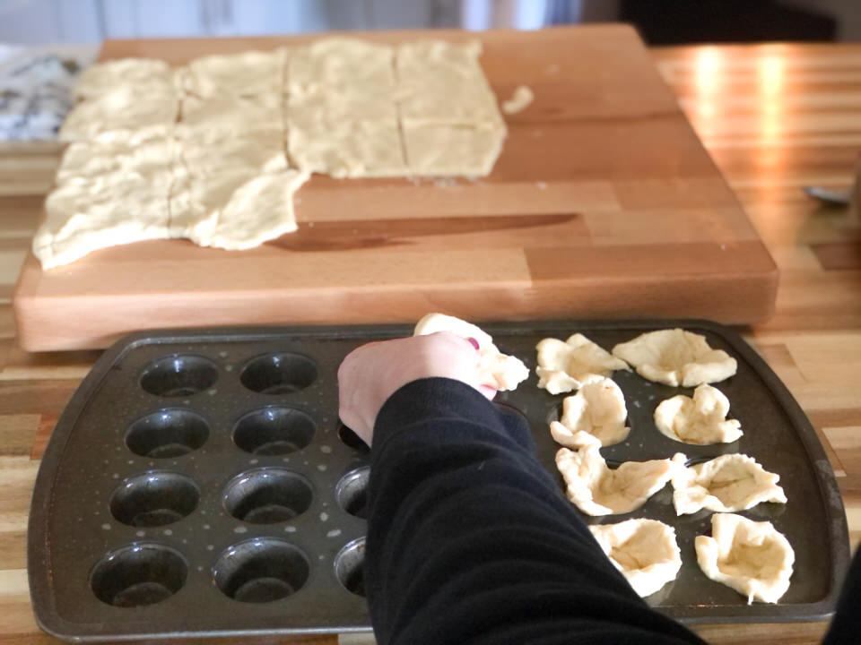 placing dough squares in mini muffin tin