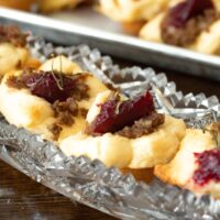 close up of sausage brie bites with cranberry in a crystal dish