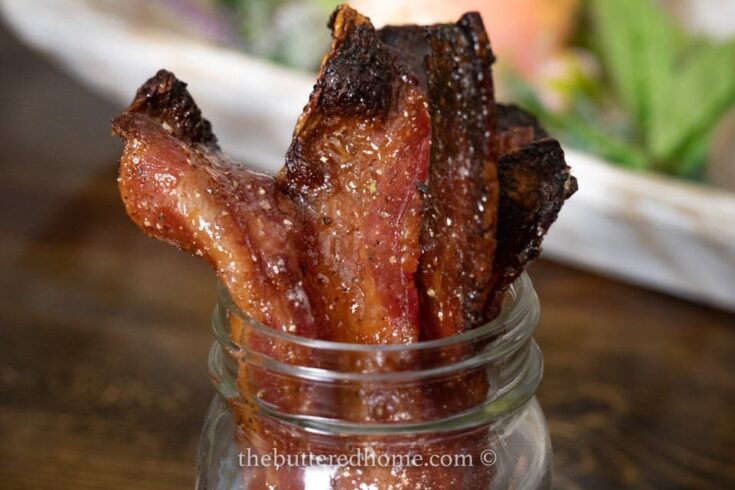 tops of candied maple bacon sitting in a jar
