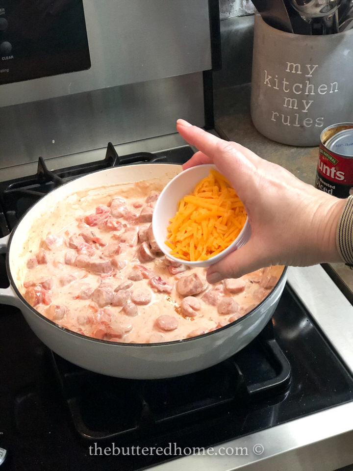 Adding shredded cheddar cheese.