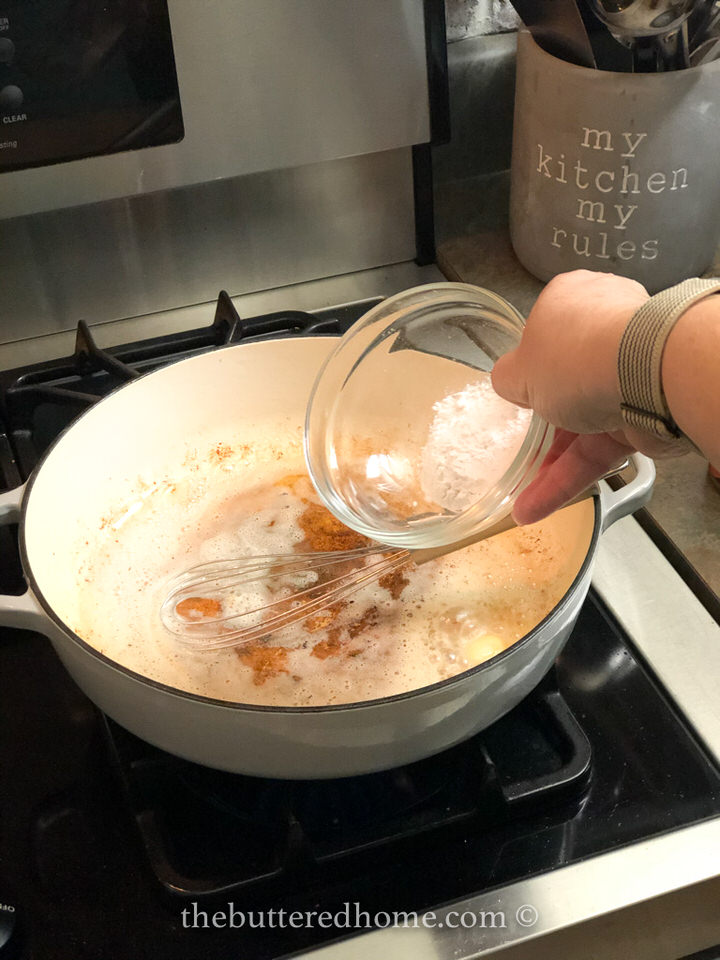 Adding flour to the grease to make a roux.