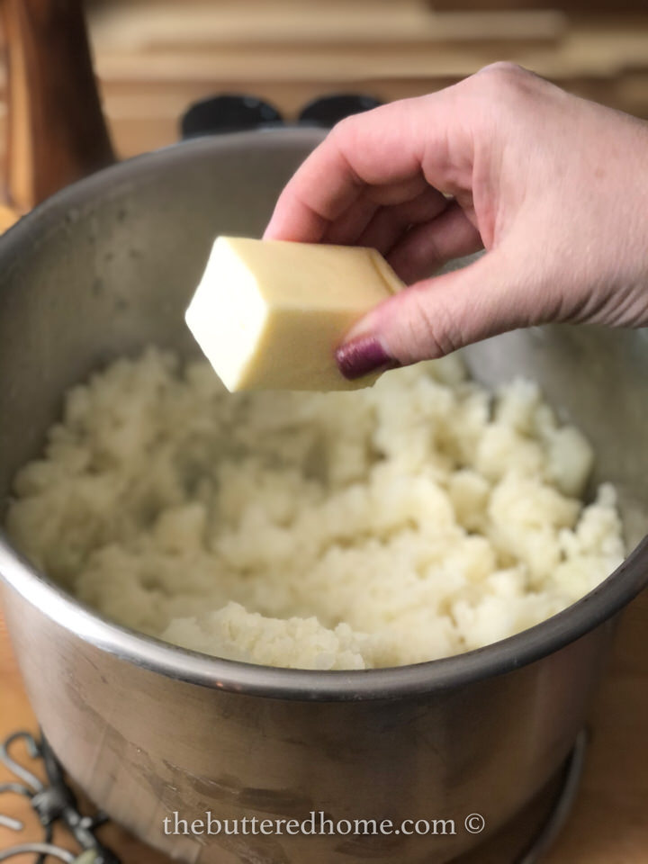 adding butter to potatoes