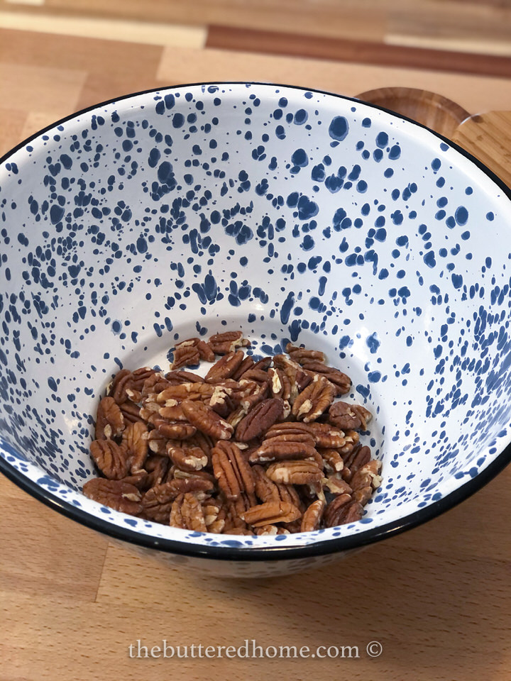 raw pecan halves in a large blue and white mixing bowl
