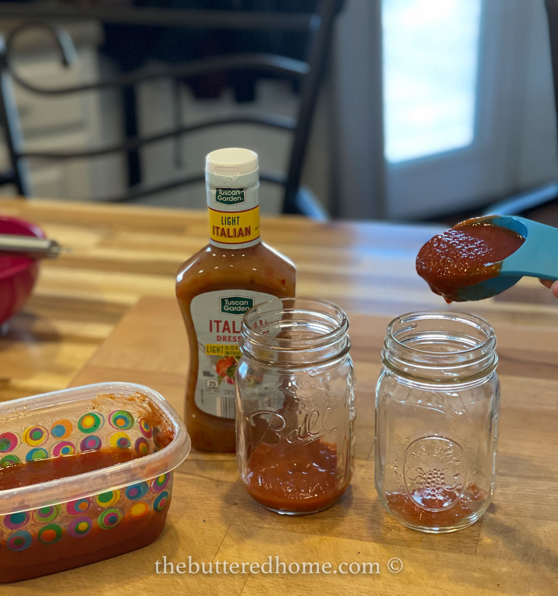 adding marinara sauce to jars