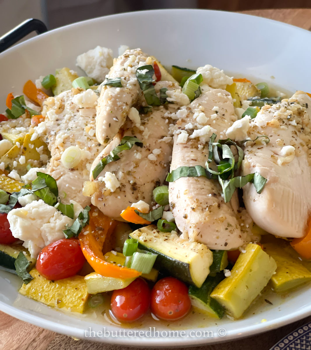 white serving dish of sheet pan chicken and vegetables