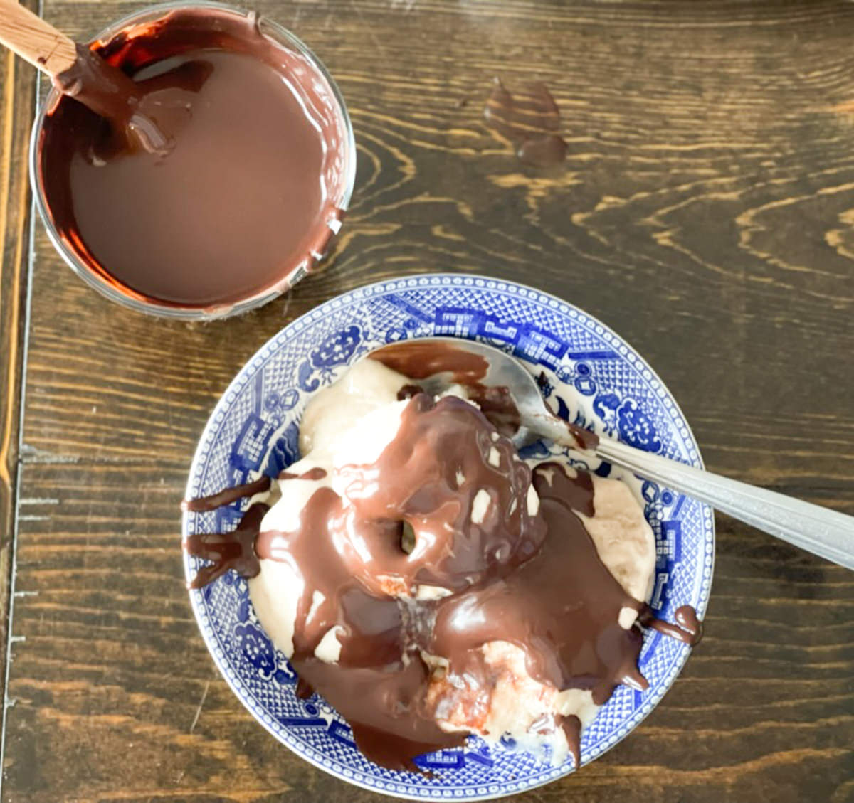 overhead view of chocolate sauce and some served over ice cream in a blue and white bowl