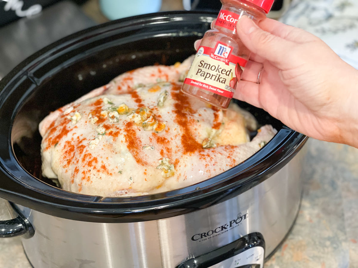 sprinkling chicken in crock pot with smoked paprika