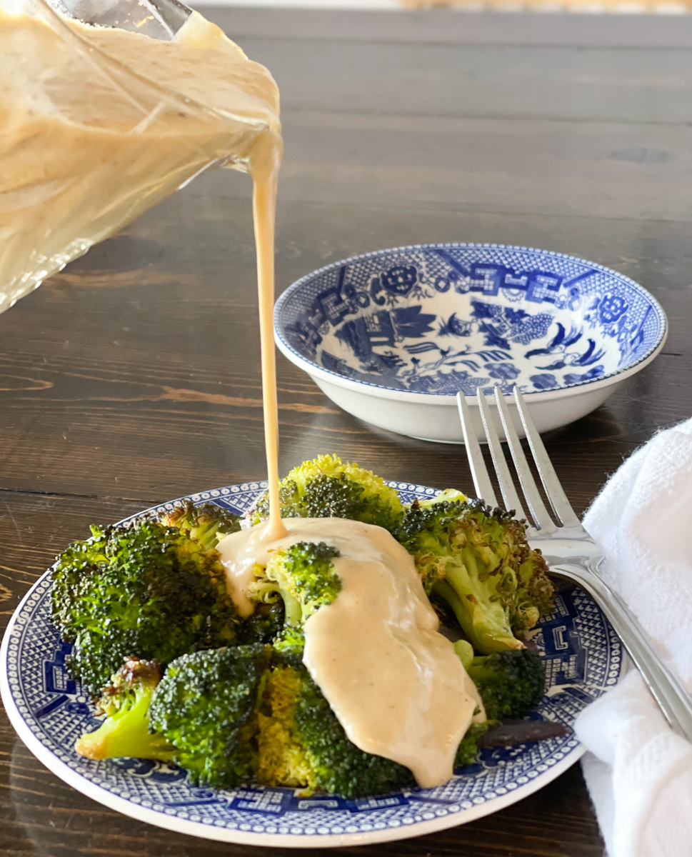 pouring cheese sauce over broccoli
