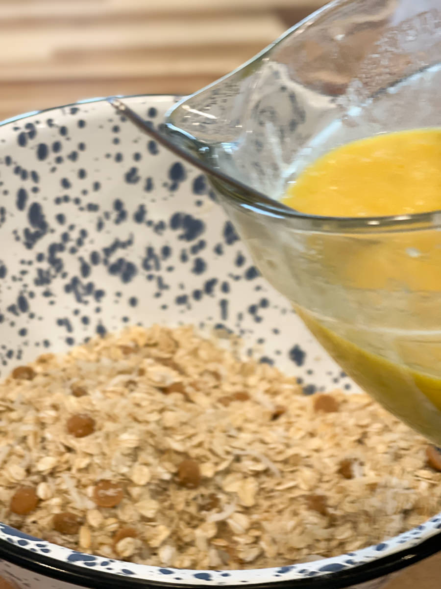 adding liquid to oats and butterscotch in a blue and white bowl