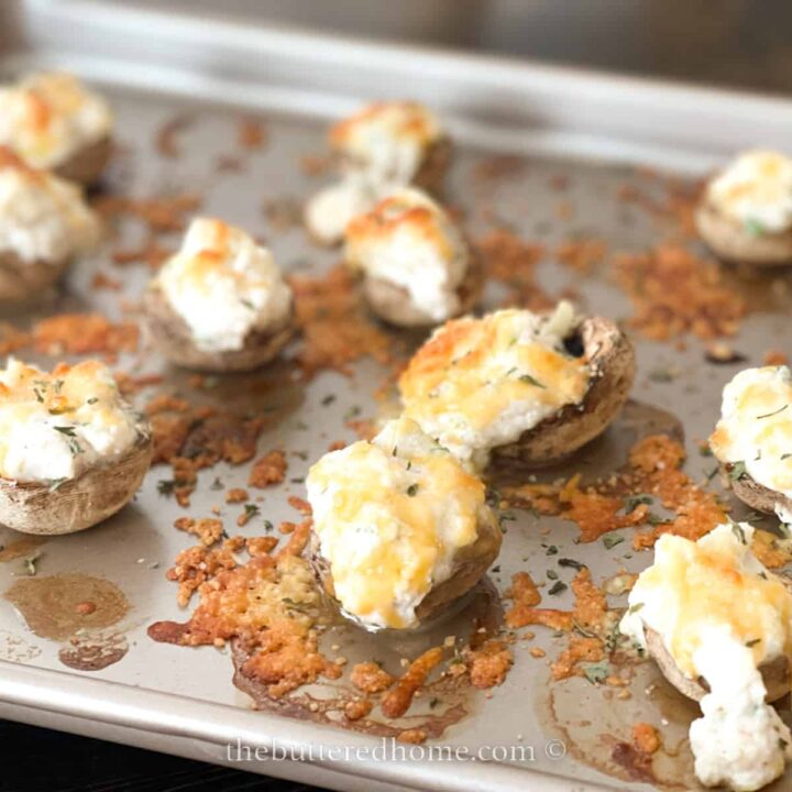 mushroom caps stuffed with seasoned crab on a sheet pan