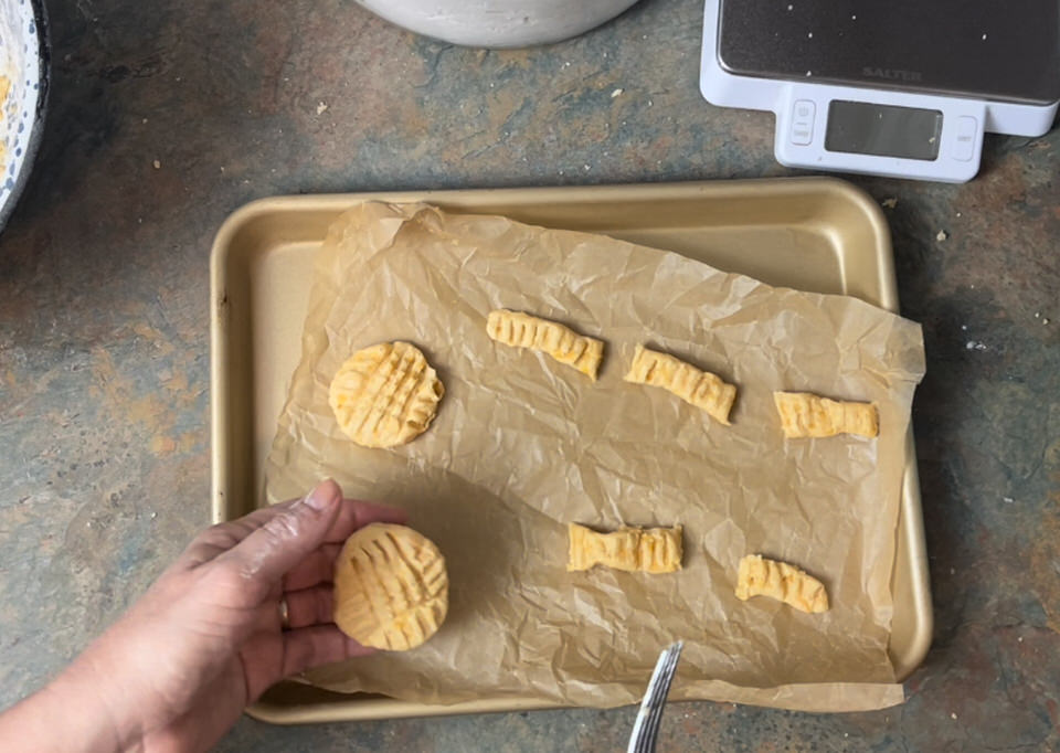 putting uncooked cheese straws on parchment lined sheet pan