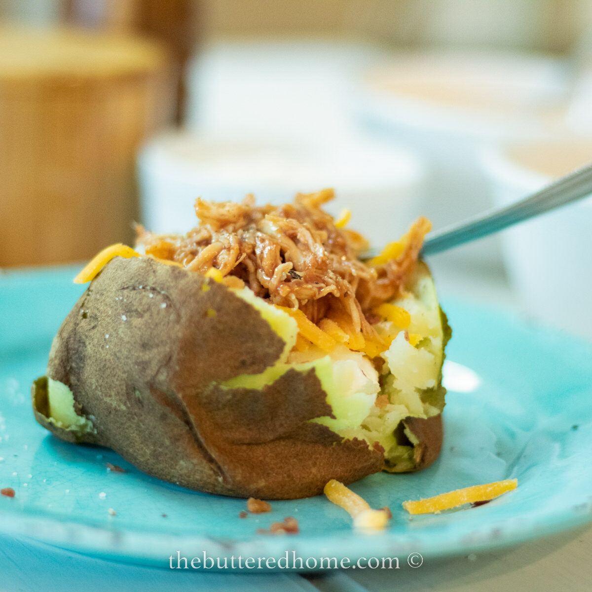Crock pot baked potato on a blue plate
