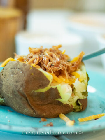 Crock pot baked potato on a blue plate
