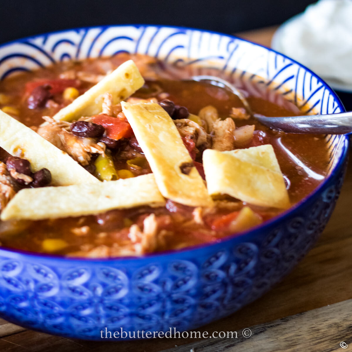 tortilla chicken soup in a blue bowl with tortilla strips