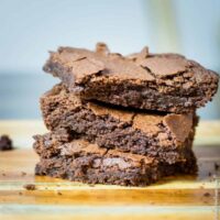 a stack of homemade brownies on a wooden board