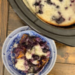 close up of blue and white bowl of cobbler with blueberries