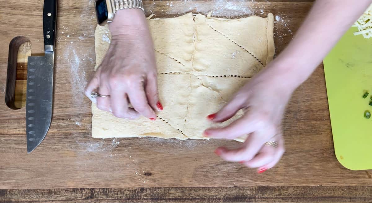 pinching seams of dough together.