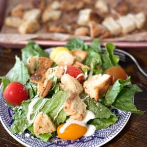 biscuit croutons on top of a green salad with cherry tomatoes.