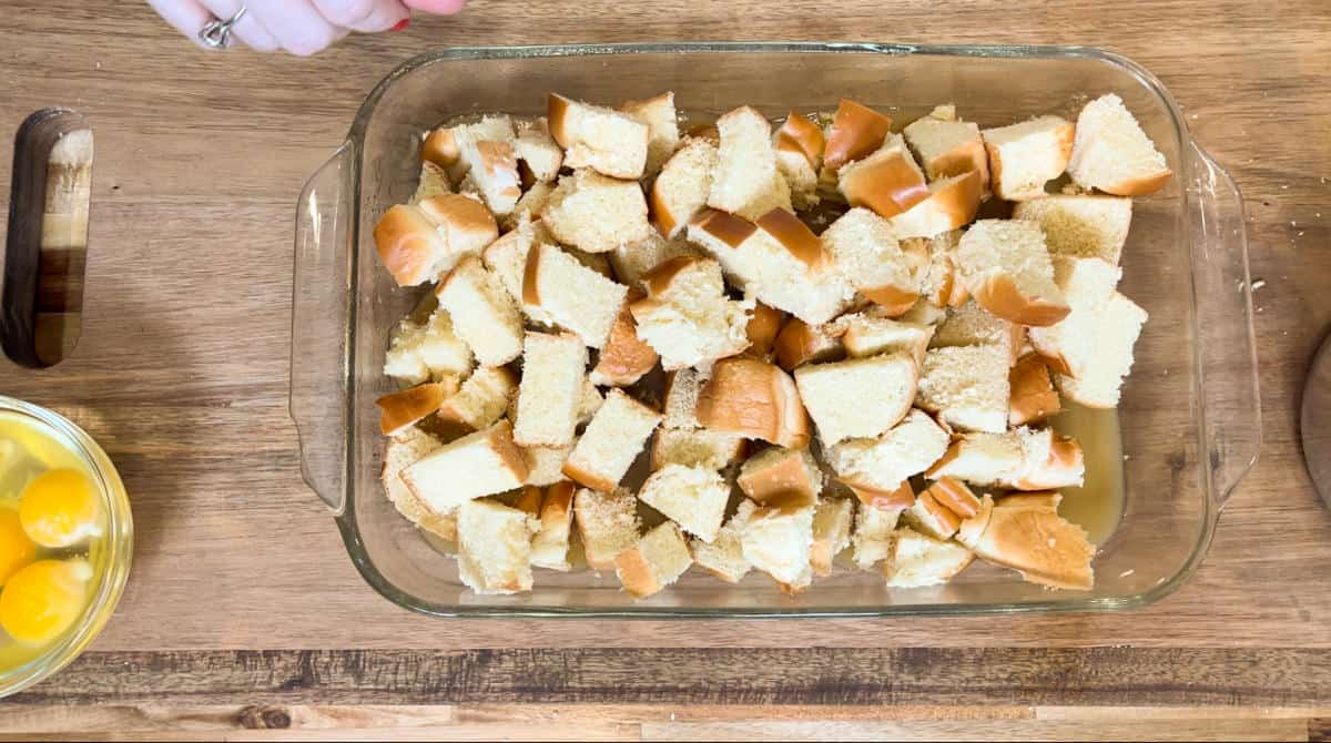 added bread on top of caramel in a clear casserole dish.