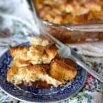 French toast casserole on a blue plate with a fork nearby.