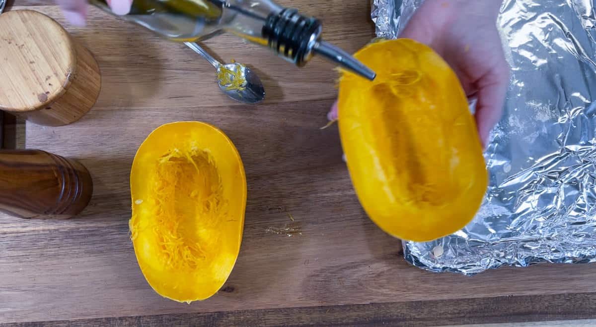 pouring olive oil over squash.