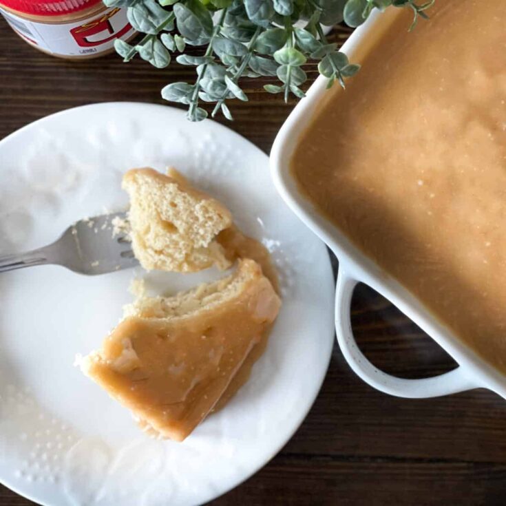 peanut butter cake bar on a white plate with a fork and a bite on the fork.