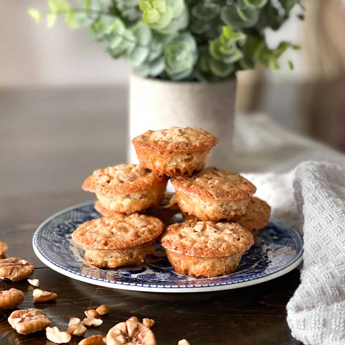 a stack of pecan pie muffins with a green plant in the background.