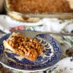 one pecan square slice with large dish in background.