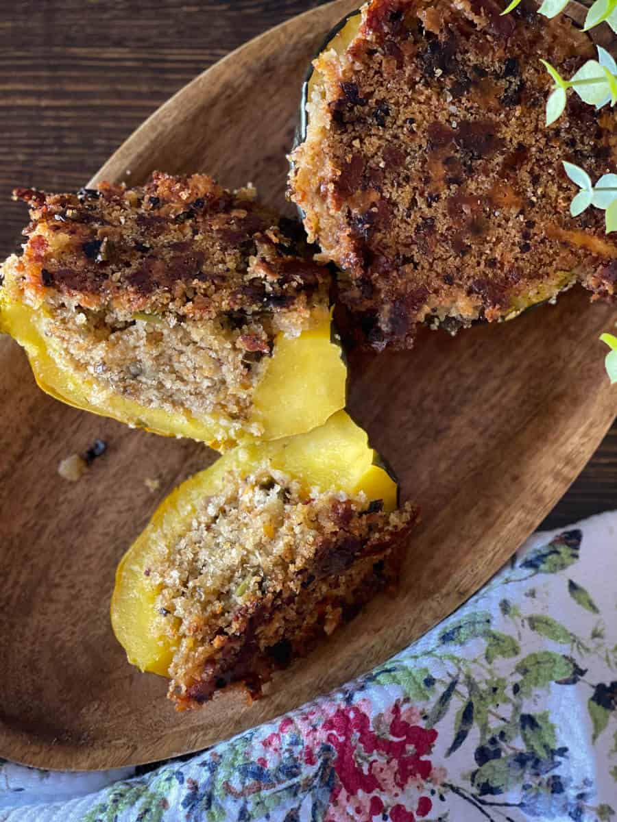 stuffed acorn squash on a wooden platter.