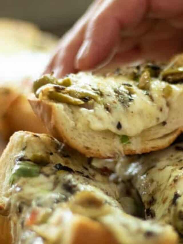 Grabbing a slice of cheesy olive bread.