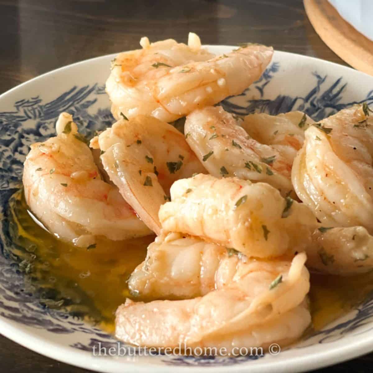 Spicy BBQ shrimp in a blue and white bowl.