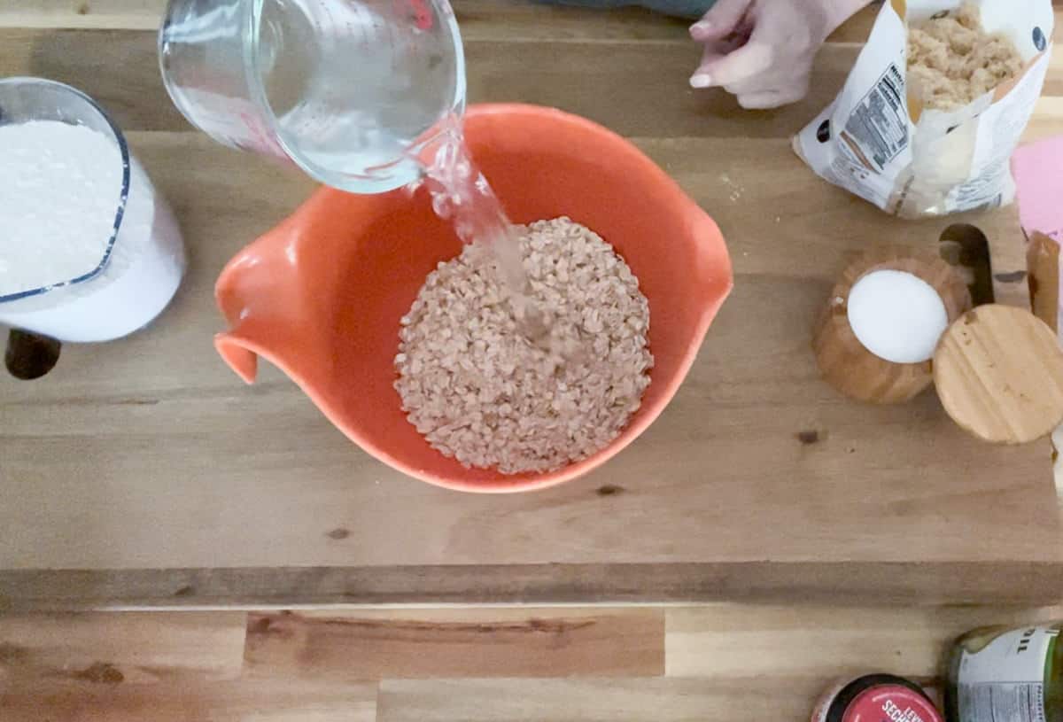 Pouring boiling water over dry oatmeal.